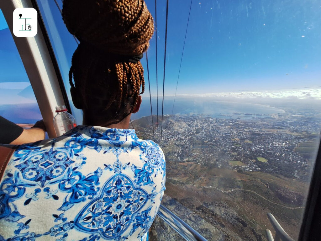 The lady passenger is enjoying the view of Cape Town from the cable car.